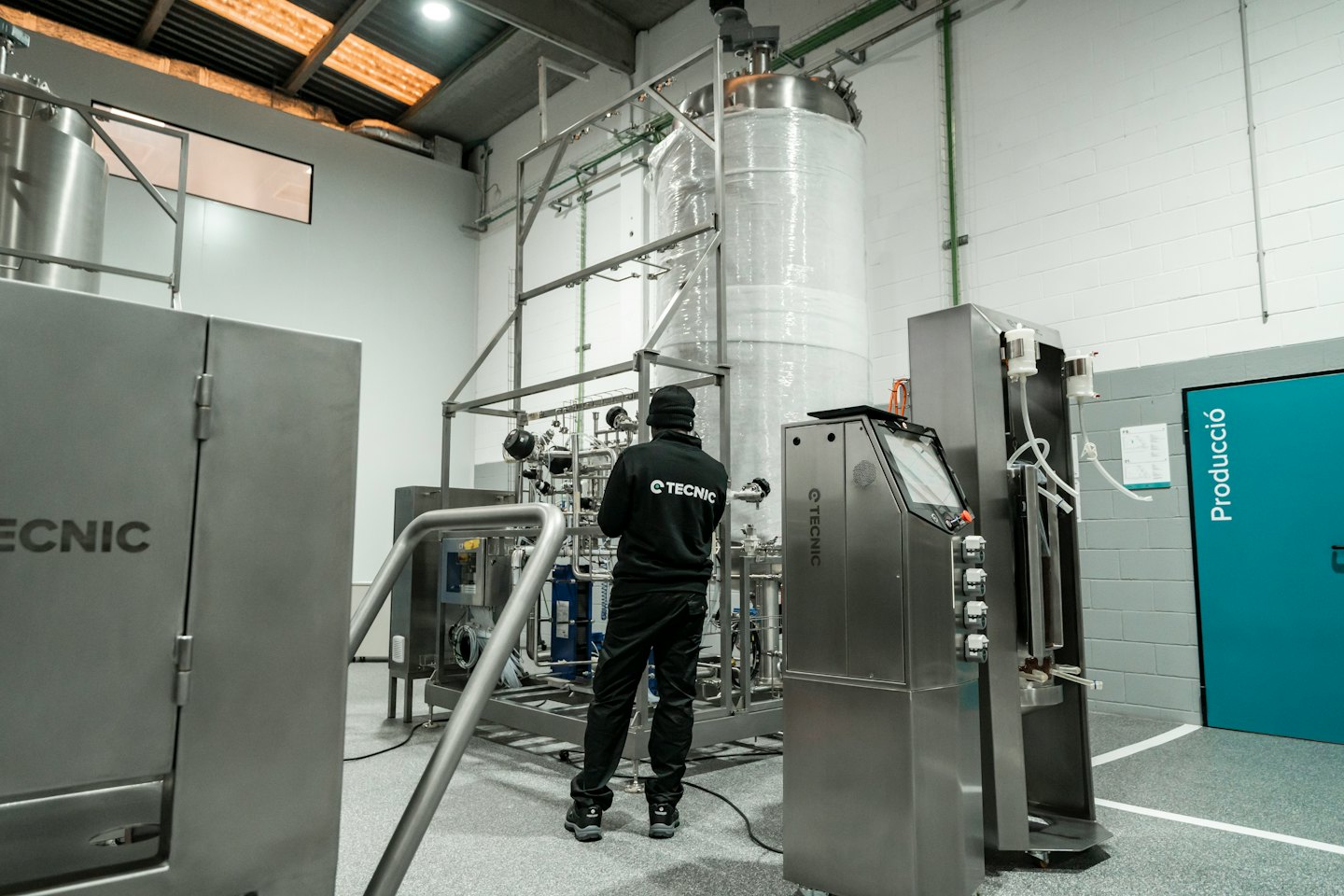 Technik inspekcjonujący skomplikowaną przemysłową maszynerię ze stali nierdzewnej.