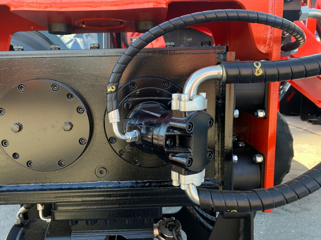 Hydraulic pump and hoses mounted on heavy industrial machinery.